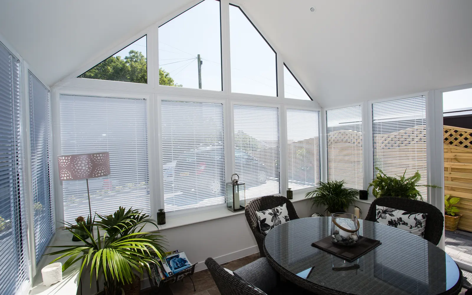 Light-filled conservatory interior with a finished ceiling, gable glazing and dining table