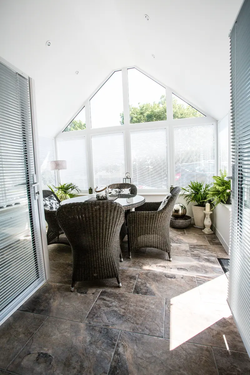 Finished conservatory interior with a plastered vaulted ceiling and gable windows