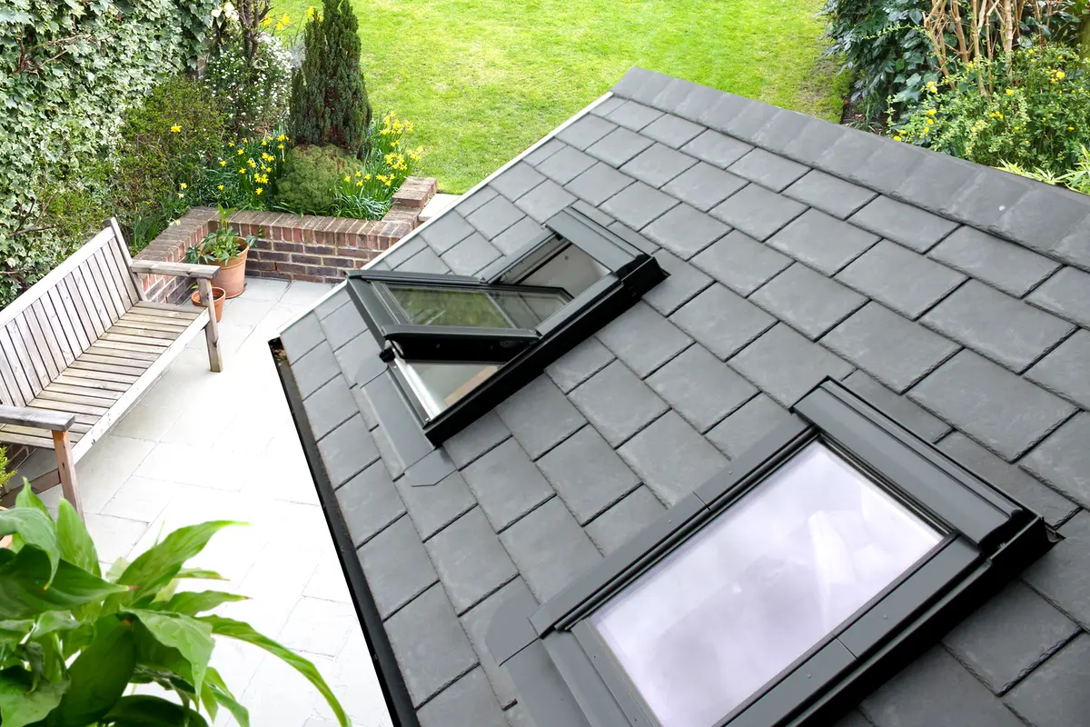 Close view of dark roof tiles and two opening rooflights on a conservatory roof